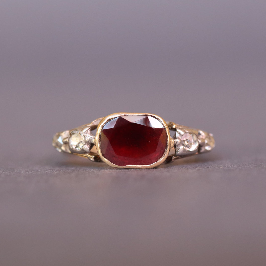 Antique Georgian ring. Flat cut garnet ring. Georgian ring. Georgian garnet ring. Rococo ring. Antique rococo ring. Antique garnet and diamond ring. Georgian garnet and diamond ring. Cusion cut garnet. Foil back ring. Foil back garnet ring. Foiled back garnet ring. Foiled back ring. Rayed butt.