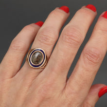 Load image into Gallery viewer, Antique Georgian sentimental ring with hairwork in a star pattern under crystal glass with a blue and white enamel border in 18ct rose gold. Oval shaped ring face. Band with arcs. CP initials. CP monogram. Mourning ring. Romantic antique ring.
