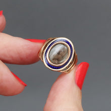 Load image into Gallery viewer, Antique Georgian sentimental ring with hairwork in a star pattern under crystal glass with a blue and white enamel border in 18ct rose gold. Oval shaped ring face. Band with arcs. CP initials. CP monogram. Mourning ring. Romantic antique ring.
