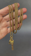 Load and play video in Gallery viewer, Antique long guard chain. Antique muff chain. Antique pinchbeck chain. Antique curb link chain. Antique chain with dog clip, lobster claw clasp, padlock, tassel. Antique Victorian chain. Pinchbeck chain.
