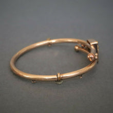 Load image into Gallery viewer, Antique Victorian era bypass bangle with garnets in 10ct gold casing
