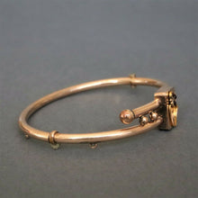 Load image into Gallery viewer, Antique Victorian era bypass bangle with garnets in 10ct gold casing
